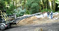 Operator remotely controlling the truck that's blowing rock into the infiltration trench.